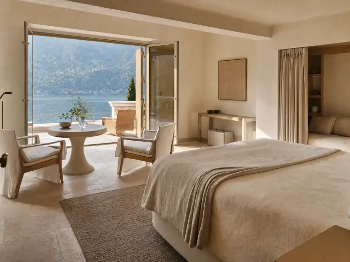 Suite con porte aperte sulla terrazza e tavolo affacciato sul lago
