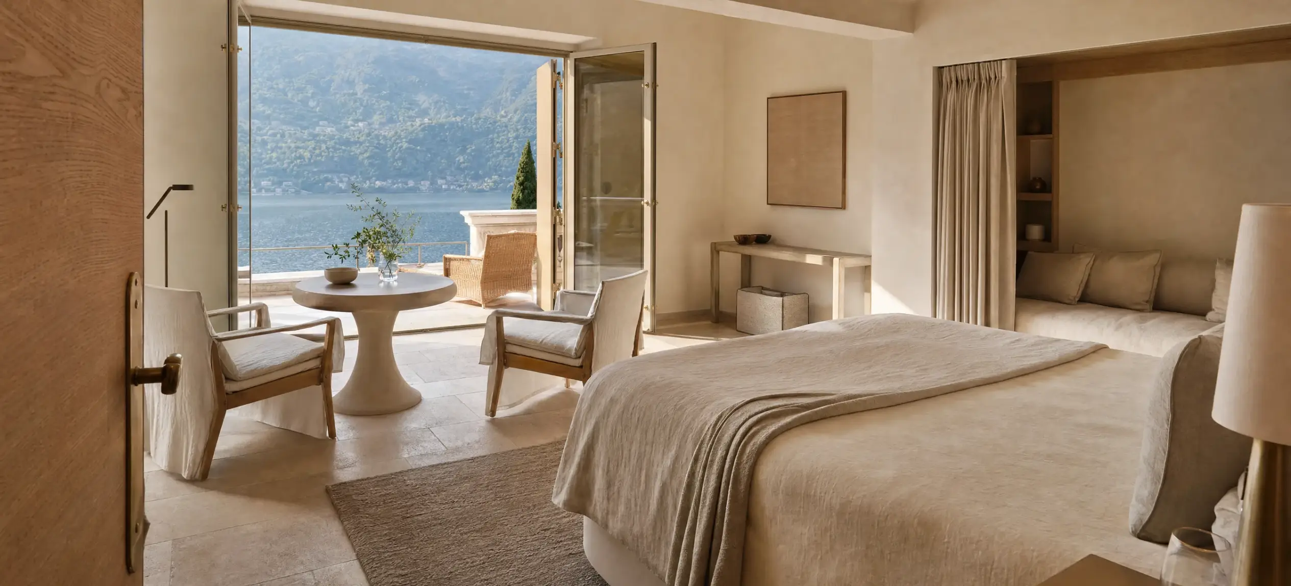 Suite con porte aperte sulla terrazza e tavolo affacciato sul lago