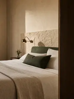 La testata in pietra e la lampada in ottone